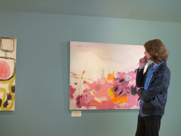 A man looking at a painting in a gallery